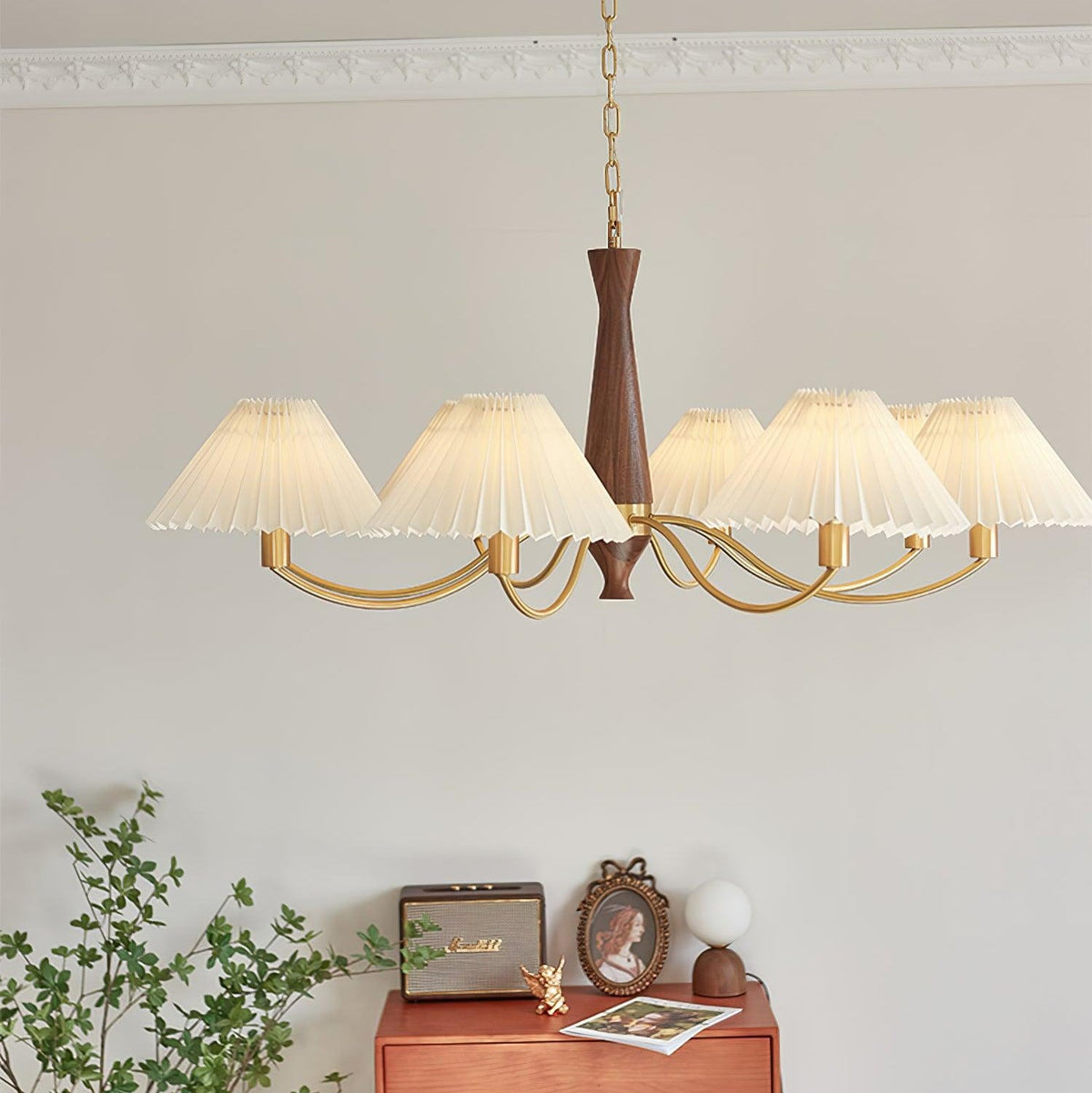 A different angle on this Clérachic chandelier shows its walnut column and pleated shades above the same dresser vignette.