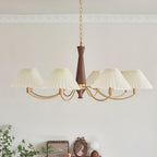 Crown moulding frames the chain of this Clérachic chandelier as its pleated shades stretch out below.