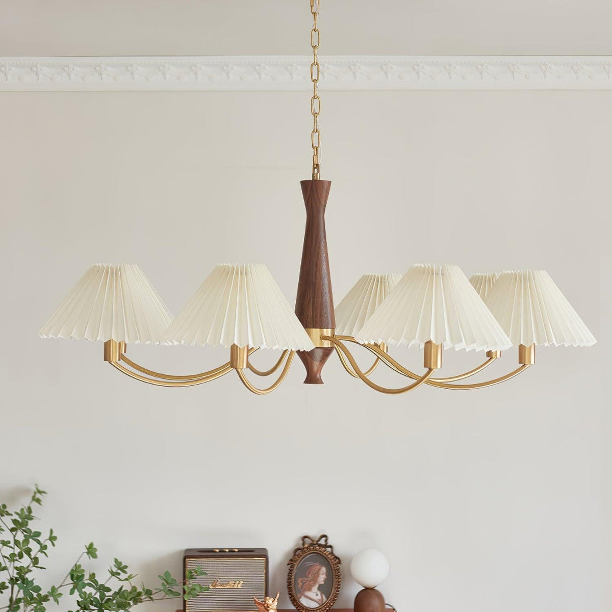 Crown moulding frames the chain of this Clérachic chandelier as its pleated shades stretch out below.