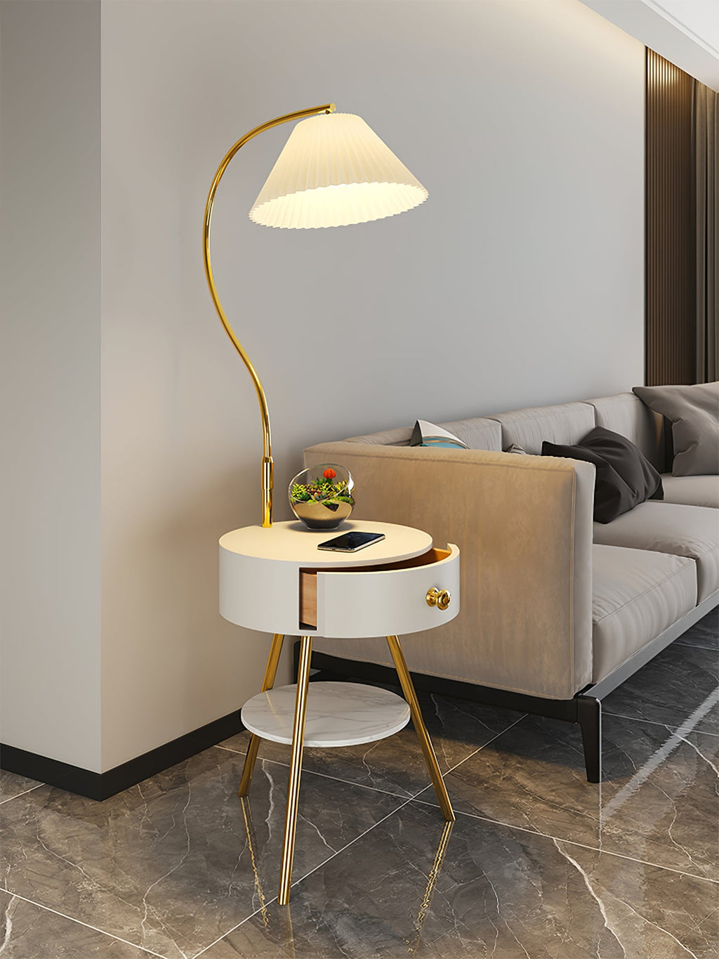 Against a panelled wall and dark marble floor, the white Clérachic lamp holds a small terrarium beside a beige sofa.