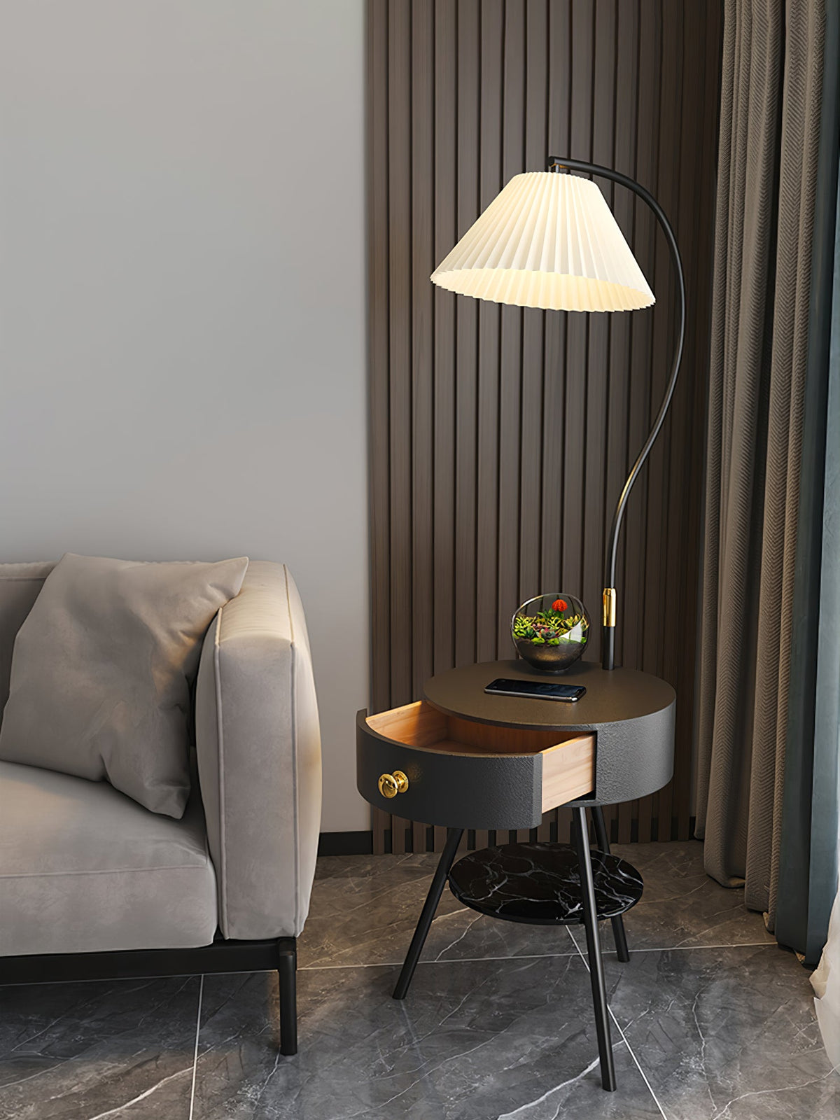 This black-and-brass Clérachic lamp holds a terrarium on its tabletop, drawer open, in the same room setting.