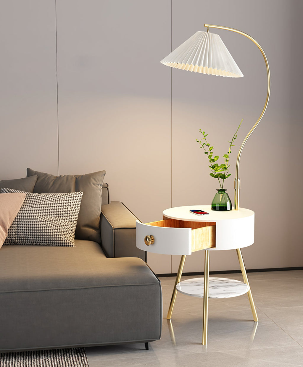 A closer view shows the Clérachic lamp's open drawer and glass vase on the white tabletop next to the grey sofa.