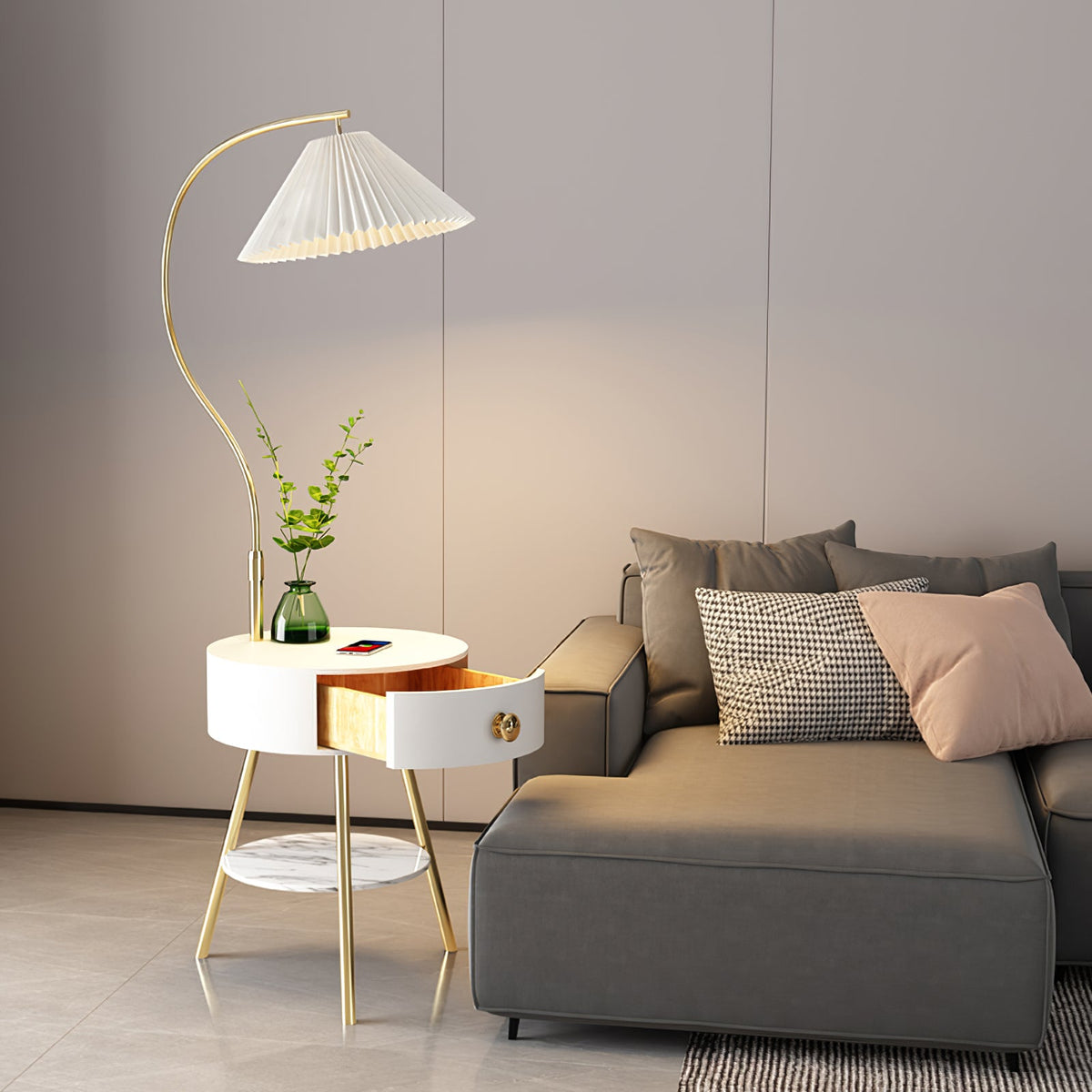 Seen from the other side, the Clérachic floor lamp's curved stem arches over the same white bedside table and grey sofa.