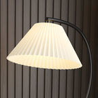 A close crop against a wood-slat wall shows the pleats of this Clérachic lamp's fabric shade in detail.