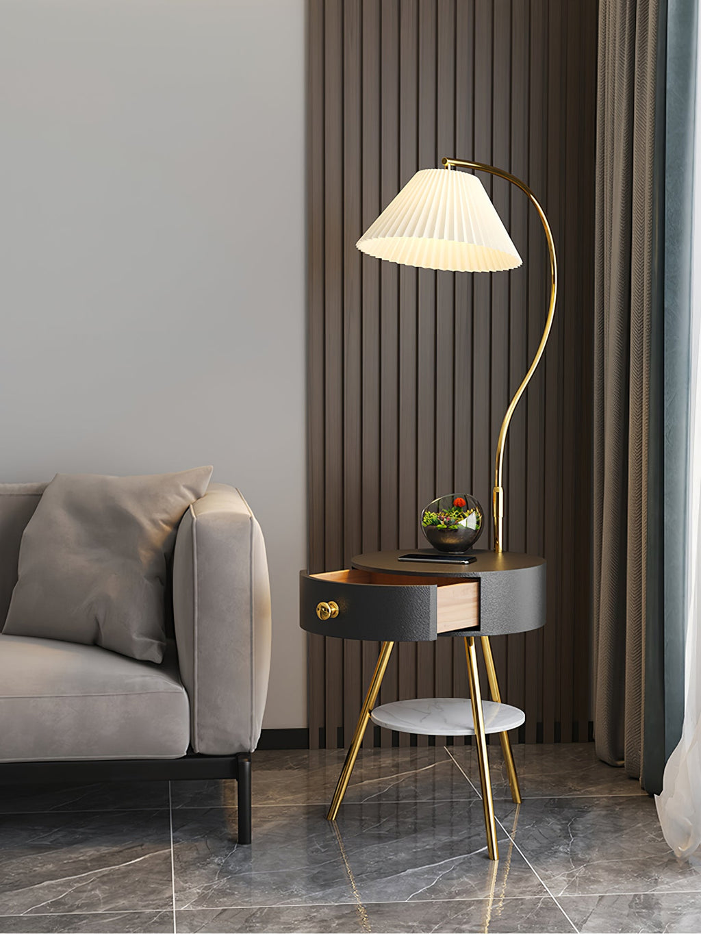 A wider view of the black-and-brass Clérachic lamp shows the terrarium, open drawer and marble floor beyond.