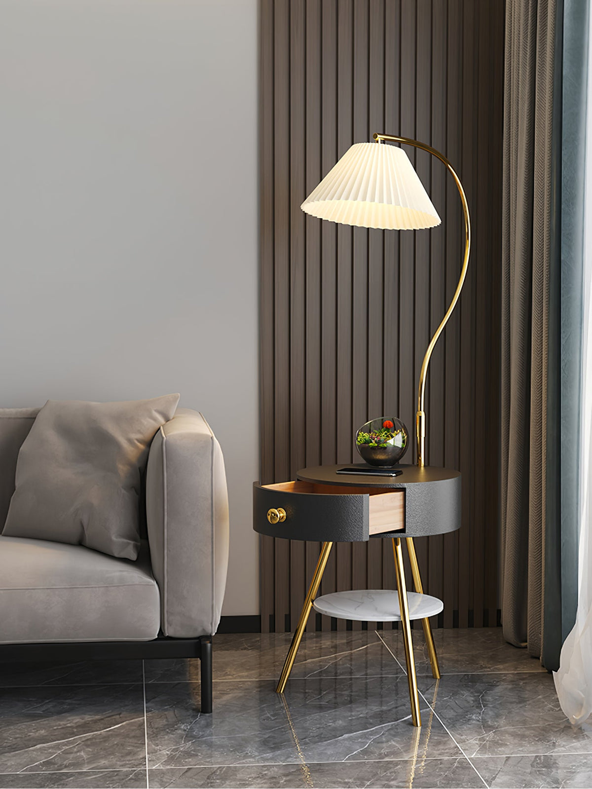 A wider view of the black-and-brass Clérachic lamp shows the terrarium, open drawer and marble floor beyond.