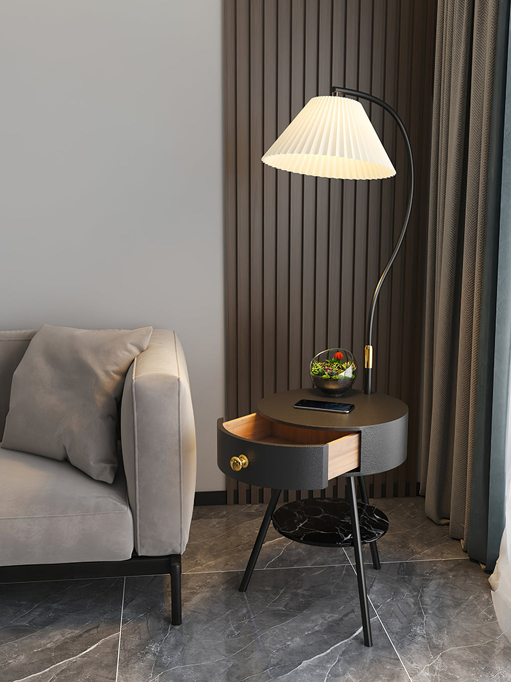 The black-and-brass Clérachic lamp holds a terrarium near a tan sofa, wood-slat wall and dark curtain.
