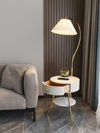 A terrarium and phone sit on the white Clérachic tabletop, drawer open, near a curtain and marble floor.
