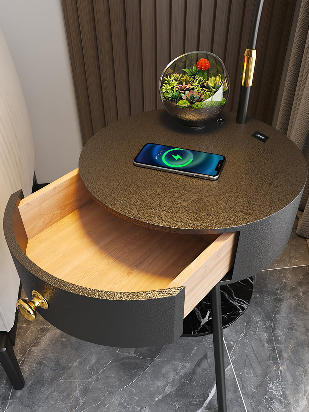 This close-up shows the Clérachic table's dark hammered top, a charging phone and the open wood-lined drawer.