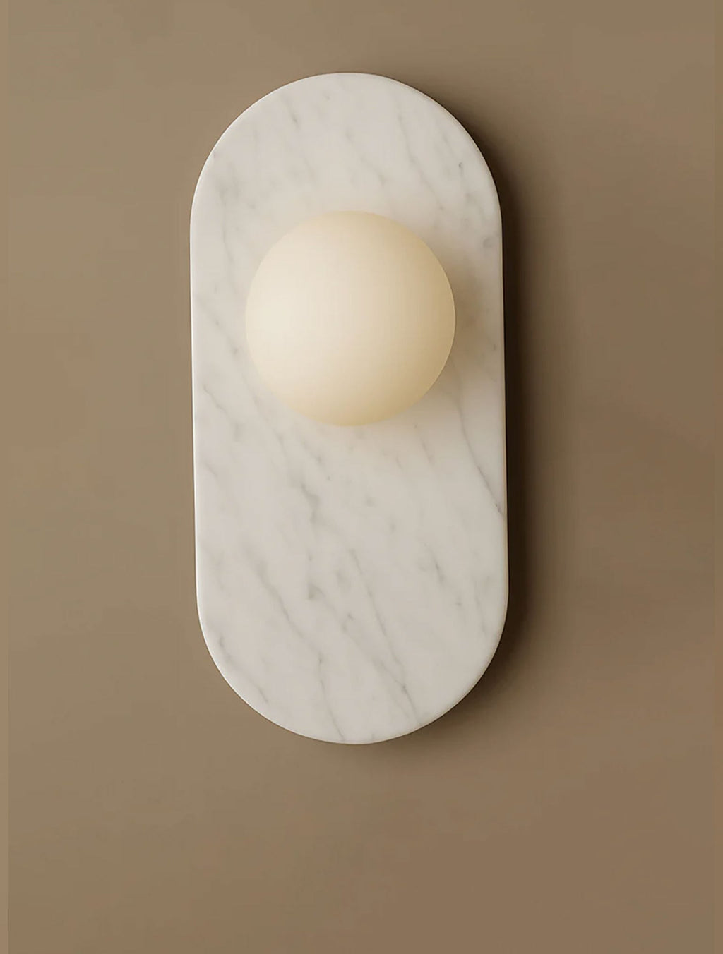 This Clérachic wall sconce pairs a white marble oval with a softly frosted glass globe, photographed against a taupe wall.