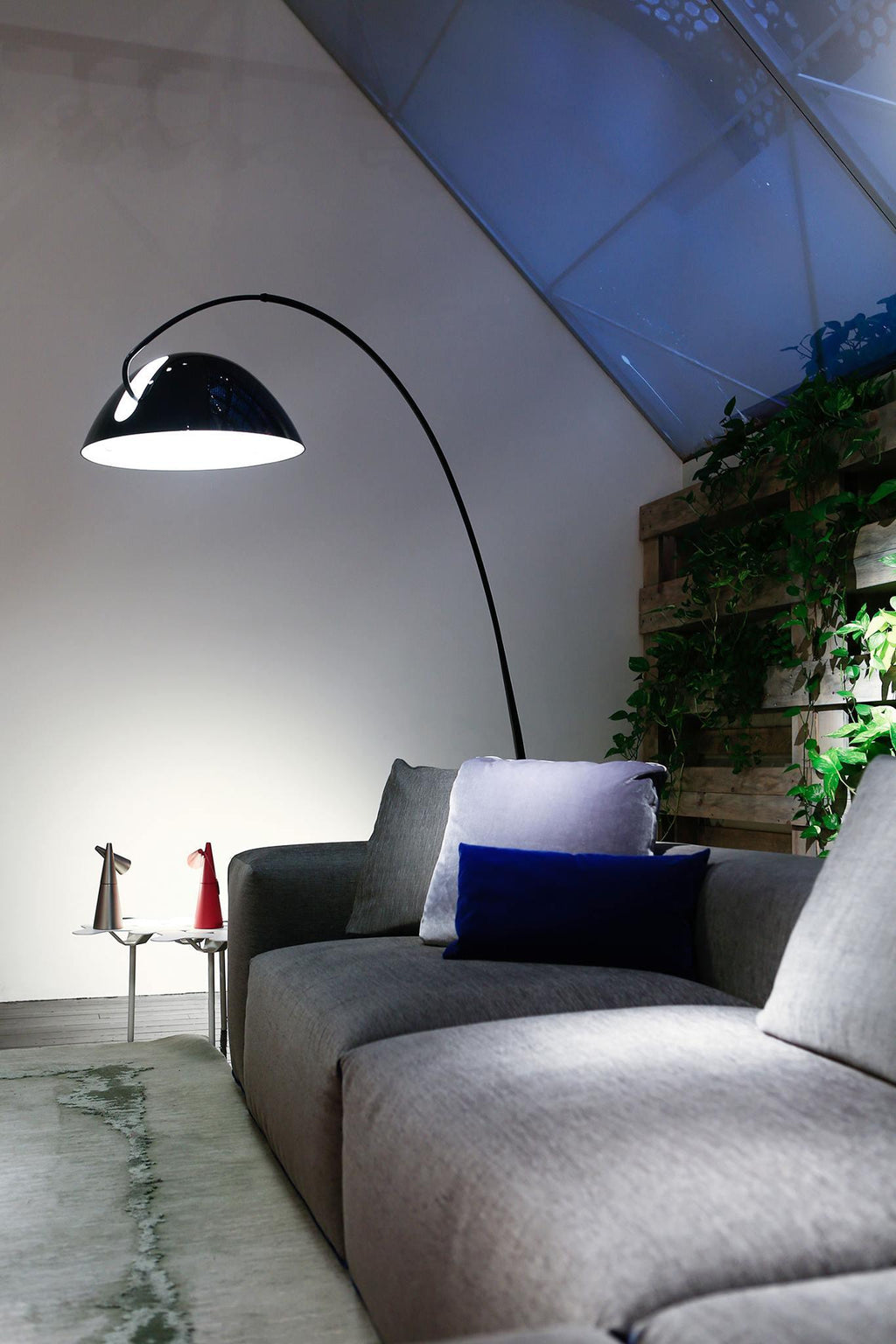 Verse arc floor lamp standing beside a lounge chair