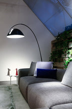 Verse arc floor lamp standing beside a lounge chair