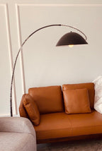 Verse arc floor lamp lit as an accent in an evening room