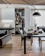 Verse arc floor lamp casting warm light over a reading nook