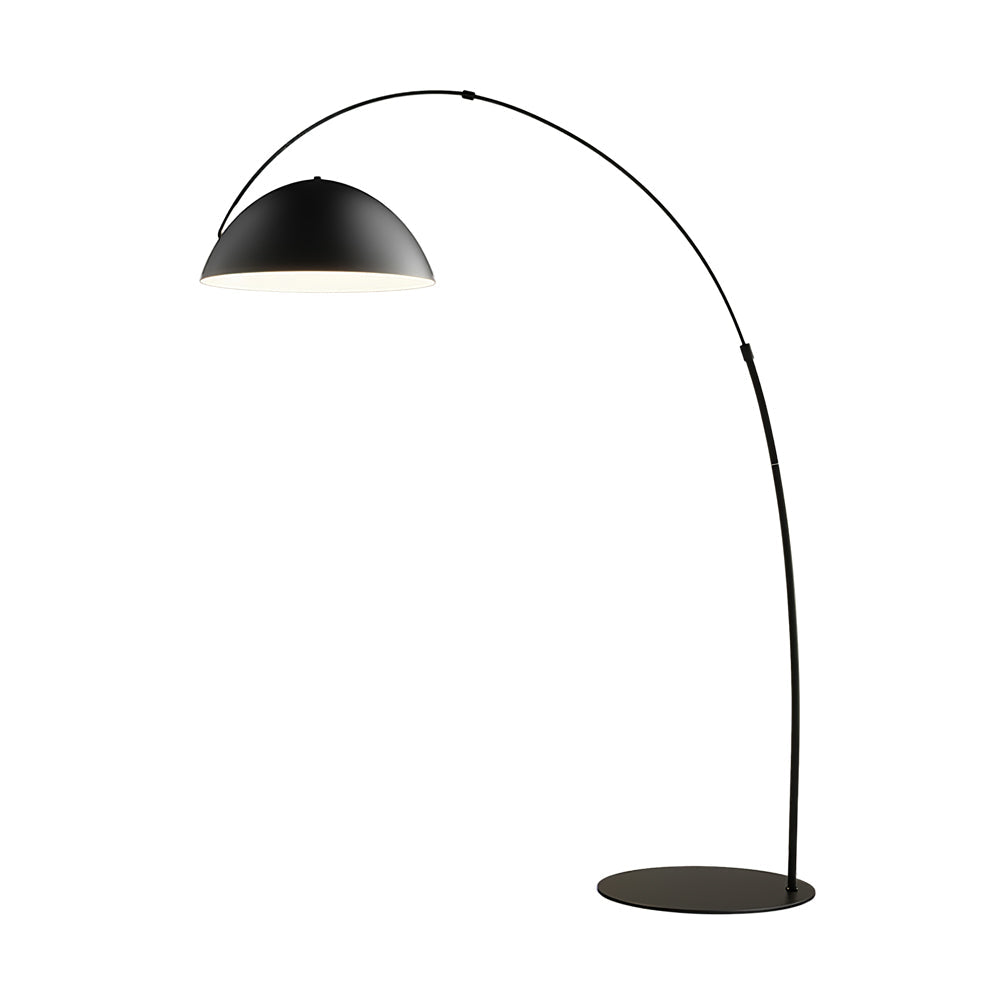 Verse arc floor lamp curving over a sofa in a styled living room