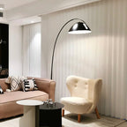 Verse arc floor lamp standing beside soft furnishings
