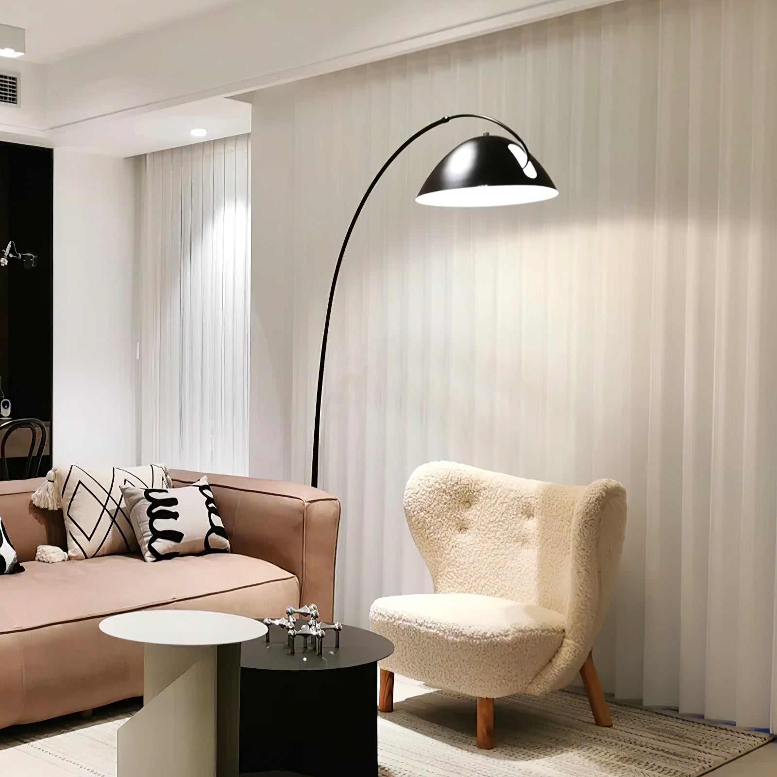 Verse arc floor lamp standing beside soft furnishings