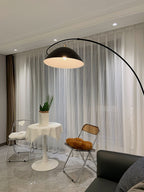 Verse arc floor lamp arcing beside a sofa in daylight