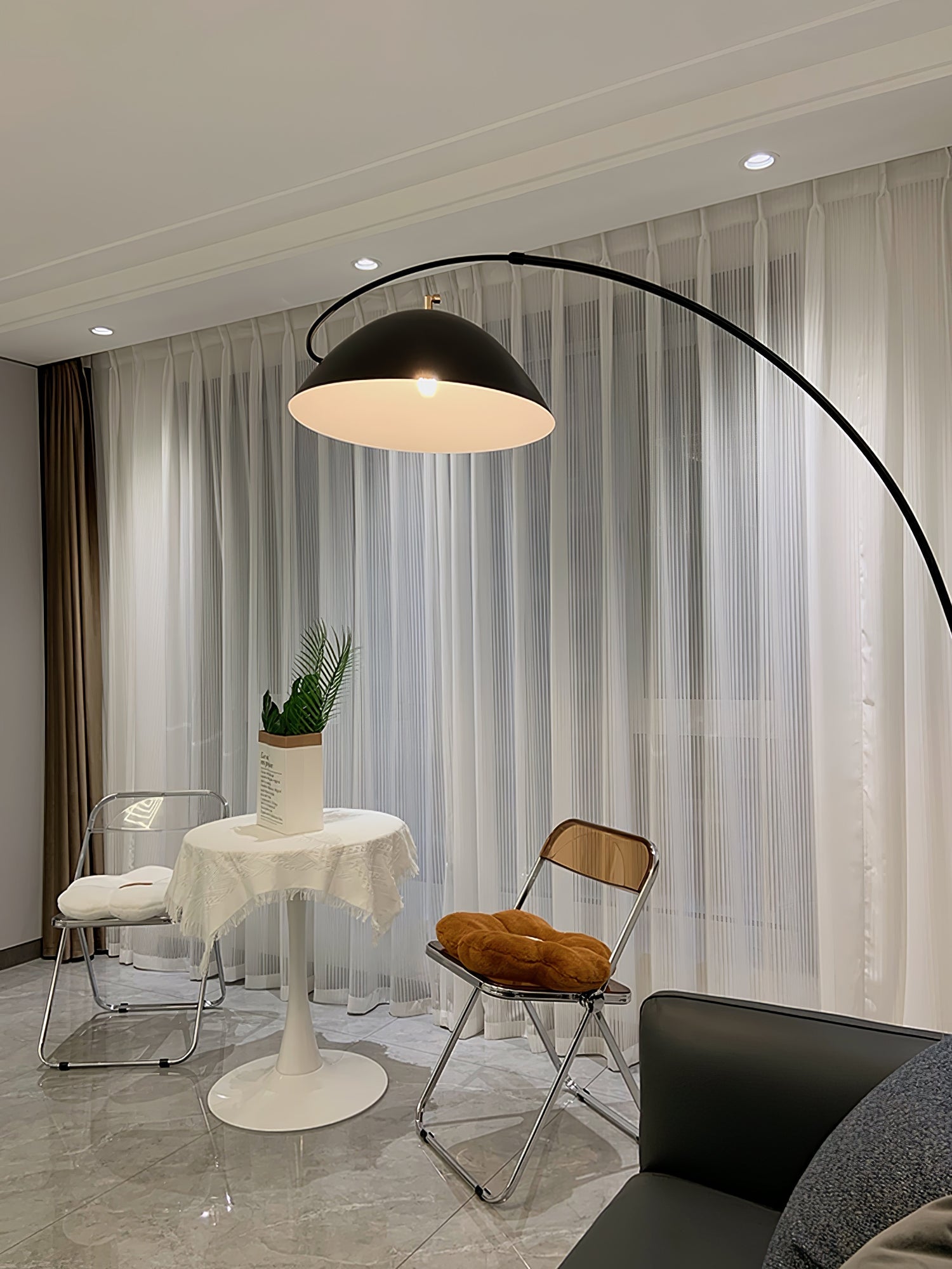 Verse arc floor lamp arcing beside a sofa in daylight