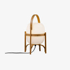 Portable lantern table lamp in wood and glass lit warmly