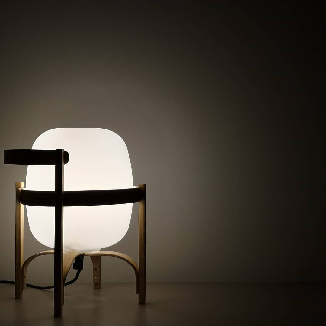 Portable lantern lamp in wood and glass on a sideboard