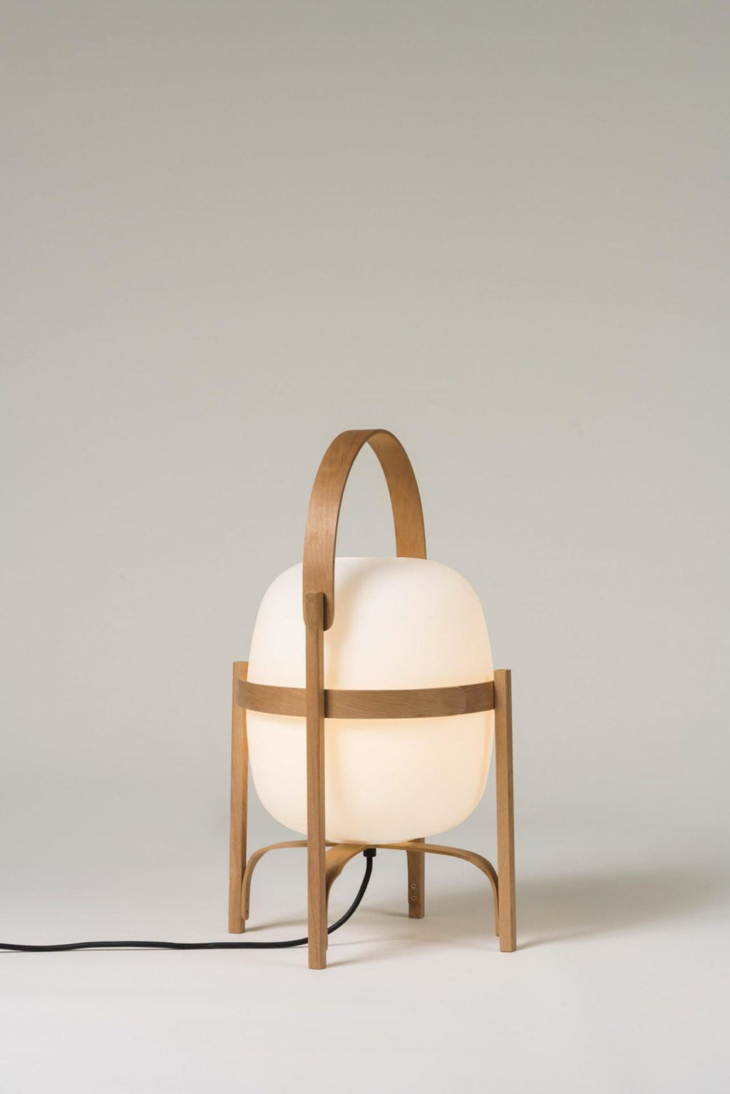 Natural wood lantern lamp glowing warmly on a table