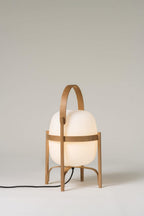 Natural wood lantern lamp glowing warmly on a table
