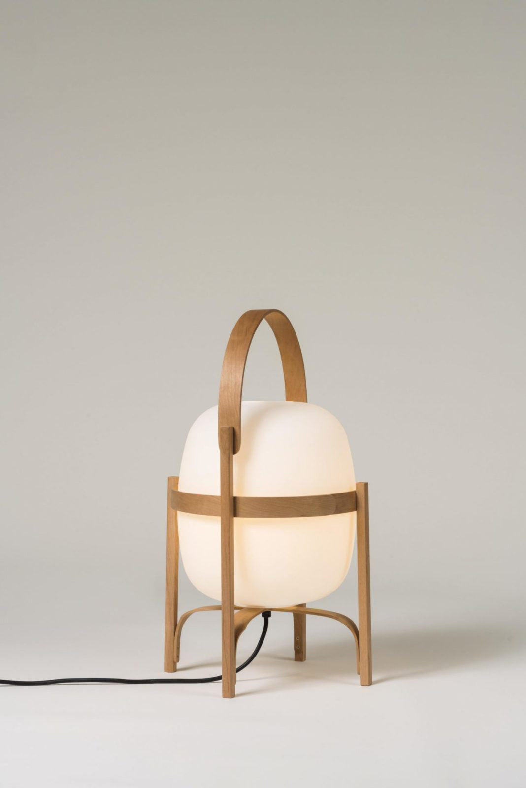 Natural wood lantern lamp glowing warmly on a table