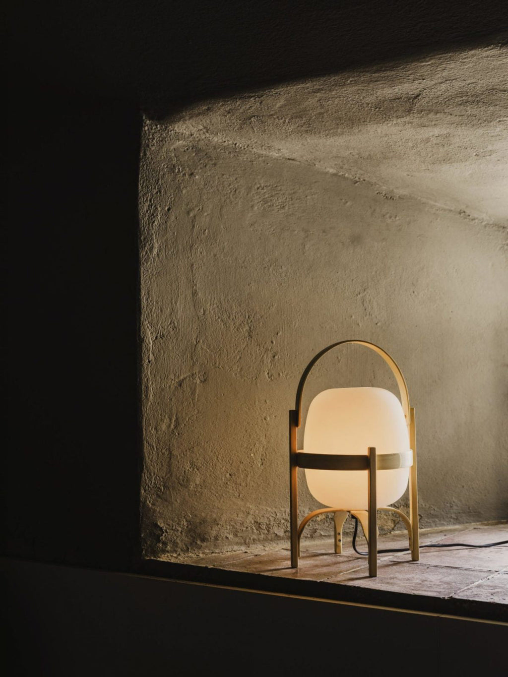 Portable lantern lamp in wood and glass on sideboard