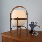 Wood-framed portable lamp with warm white glass shade