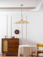This Clérachic pendant lamp in beige petals hangs near a walnut sideboard and a round table set with a jug and mustard chair.