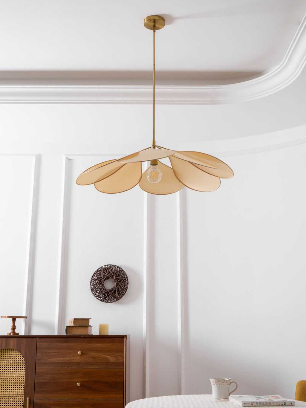 This Clérachic pendant lamp in beige petals hangs low, its bulb glowing softly beneath the fanned shade.
