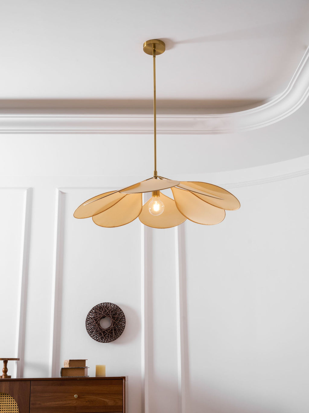 This Clérachic pendant lamp in beige petals hangs centred in a panelled room, its bulb visible among the petals.