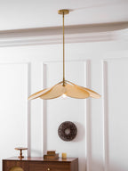 This Clérachic pendant lamp in beige petals hangs above a walnut sideboard, with a woven wall wreath in the background.