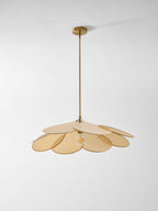 This Clérachic pendant lamp in beige petals hangs low against a plain grey background, its bulb glowing at the centre.