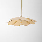 Studio shot of this Clérachic pendant lamp seen from above, its beige petals overlapping around a dim bulb.