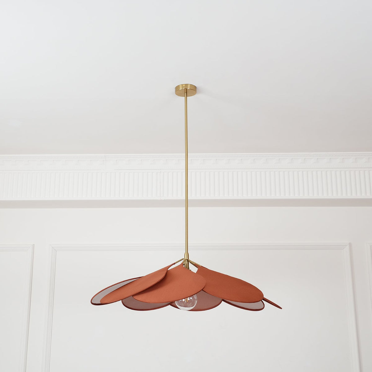 Hanging centred beneath a panelled ceiling, this Clérachic pendant lamp shows terracotta petals fanned into a wide dome.