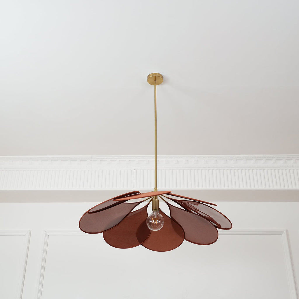Seen from below, this Clérachic pendant lamp's rust-brown petals fan out evenly around a glowing bulb.