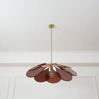 Seen from below, this Clérachic pendant lamp's rust-brown petals fan out evenly around a glowing bulb.