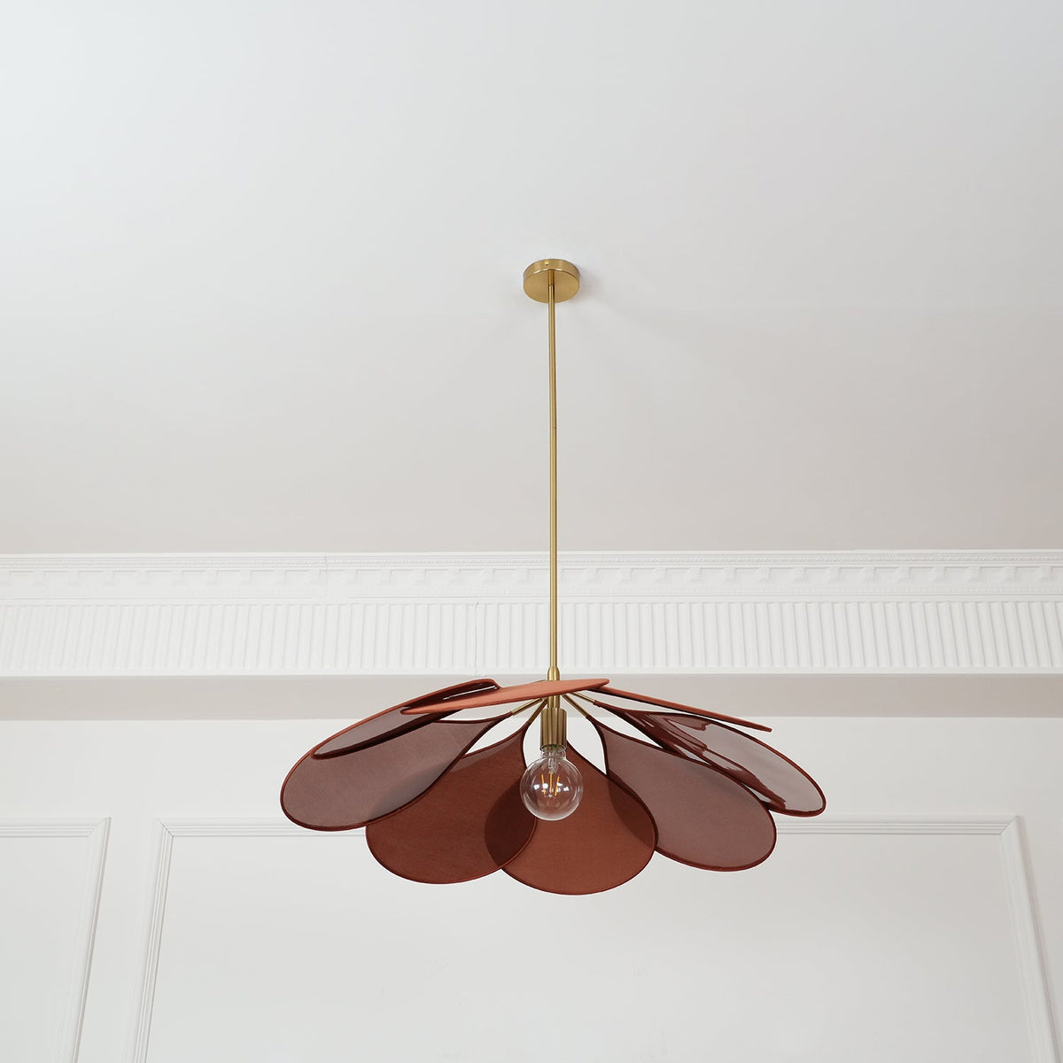 Seen from below, this Clérachic pendant lamp's rust-brown petals fan out evenly around a glowing bulb.
