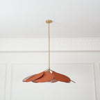 This Clérachic pendant lamp in terracotta petals hangs high on a long brass stem, splayed loosely to one side.