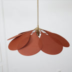 Close view of this Clérachic pendant lamp's terracotta petals, fanned wide and filling the frame against a white wall.