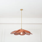 Studio shot of this Clérachic pendant lamp from below, its terracotta fabric petals fanned open around a glowing bulb on a brass stem.