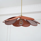 Seen from directly below, this Clérachic pendant lamp's terracotta petals fan out around a glowing bulb.