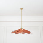 Seen from a distance, this Clérachic pendant lamp's terracotta petals hang high on their brass stem in a plain room.