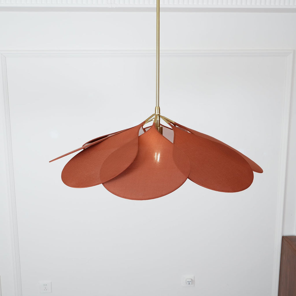 Close view from below of this Clérachic pendant lamp's terracotta petals, fanned unevenly against a plain wall.