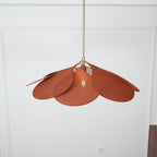 Close view from below of this Clérachic pendant lamp's terracotta petals, fanned unevenly against a plain wall.
