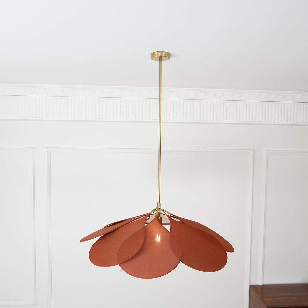 Shown at a slight distance, this Clérachic pendant lamp's terracotta petals form a compact dome in a panelled room.