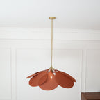 Shown at a slight distance, this Clérachic pendant lamp's terracotta petals form a compact dome in a panelled room.