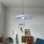 This Clérachic pendant lamp in pale blue petals hangs above a white console beside a patterned tile-front cabinet and a blue chair.